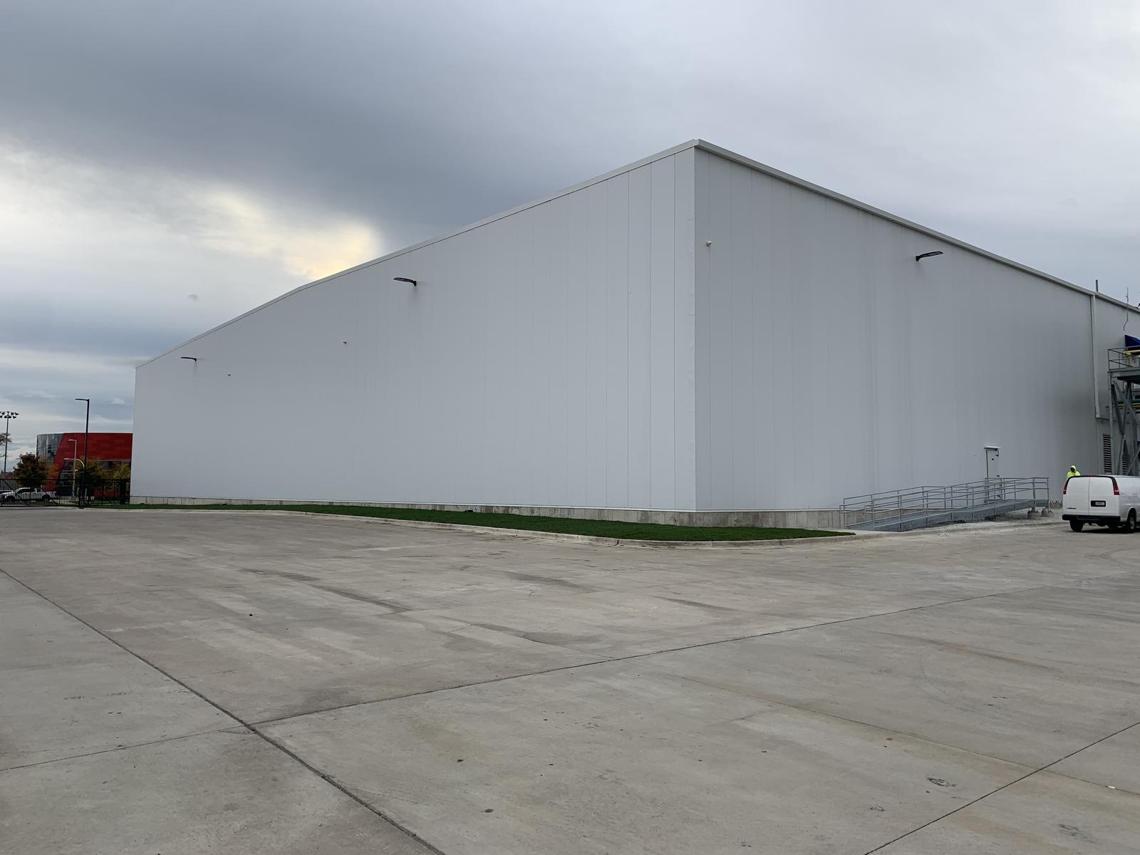 Completed insulated metal panel freezer addition seen from the plant yard under an overcast sky