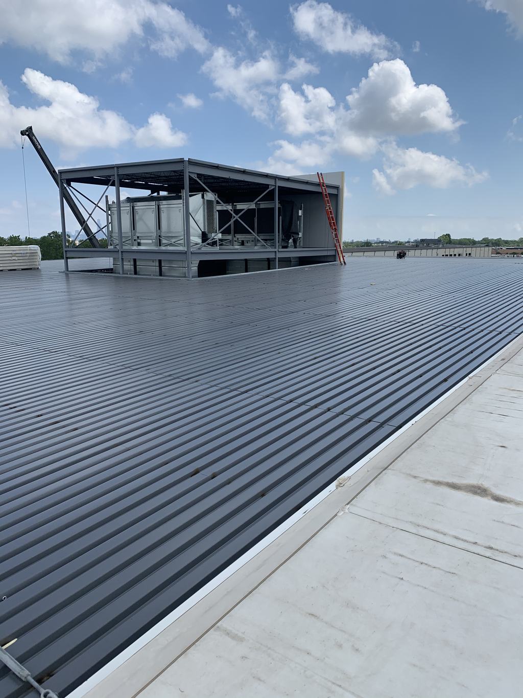 Steel-framed refrigeration penthouse under construction on the roof of the freezer addition, with equipment set inside the frame