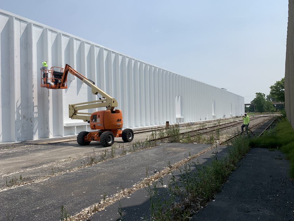 Boom lift working the long exterior wall of the distribution building